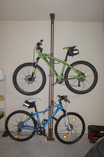 Photograph of Gear Up OakRak floor to ceiling bike storage rack with mountainbike and a hybrid on it.